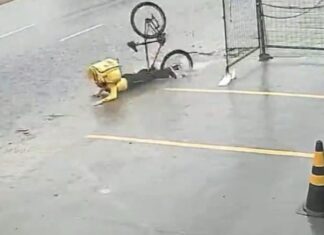 Em Manaus, motoboy cai após bicicleta afundar em buraco coberto por água da chuva
