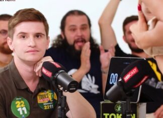 Vereador bolsonarista desvia o olhar após travesti mostrar os seios em debate